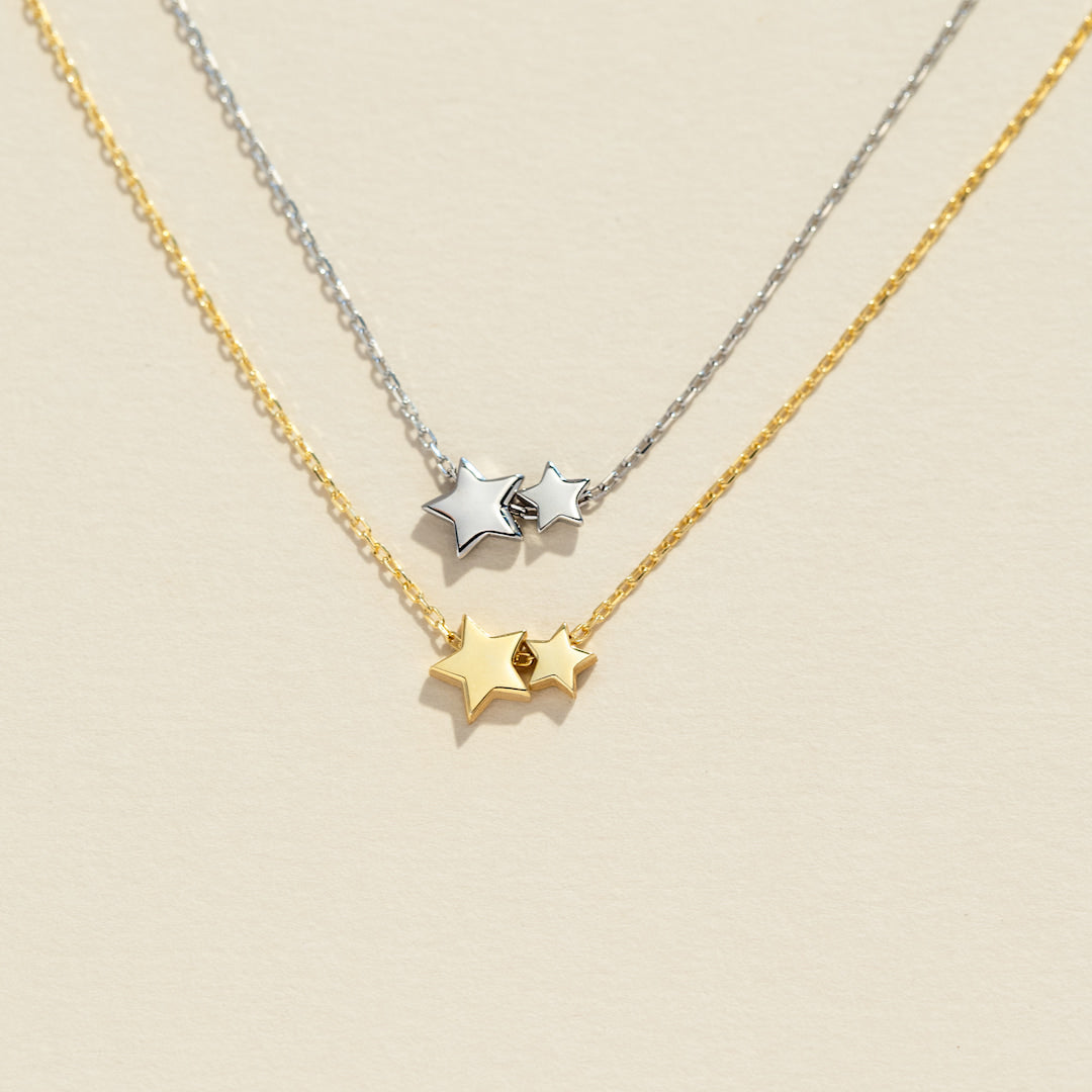 Two star-shaped necklaces on a beige background