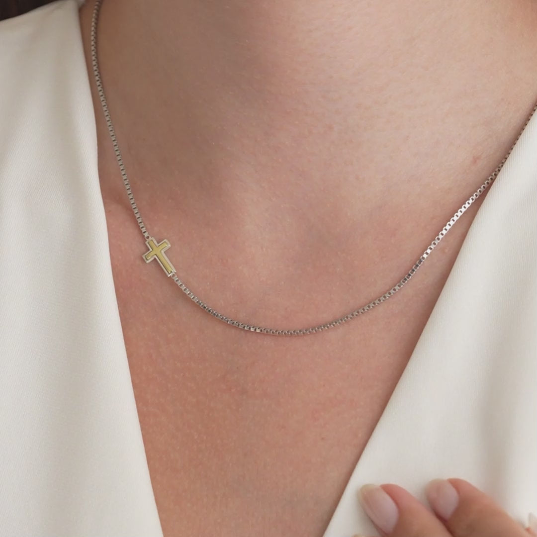 Video: two-tone sideways cross box chain necklace worn at the neckline, then held in the hand to show the cross up close