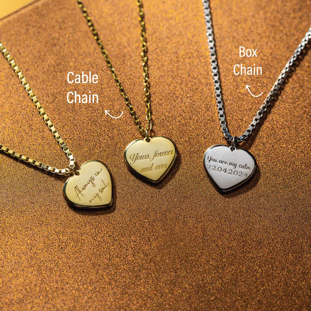 Three heart-shaped pendants on different chains on a brown background
